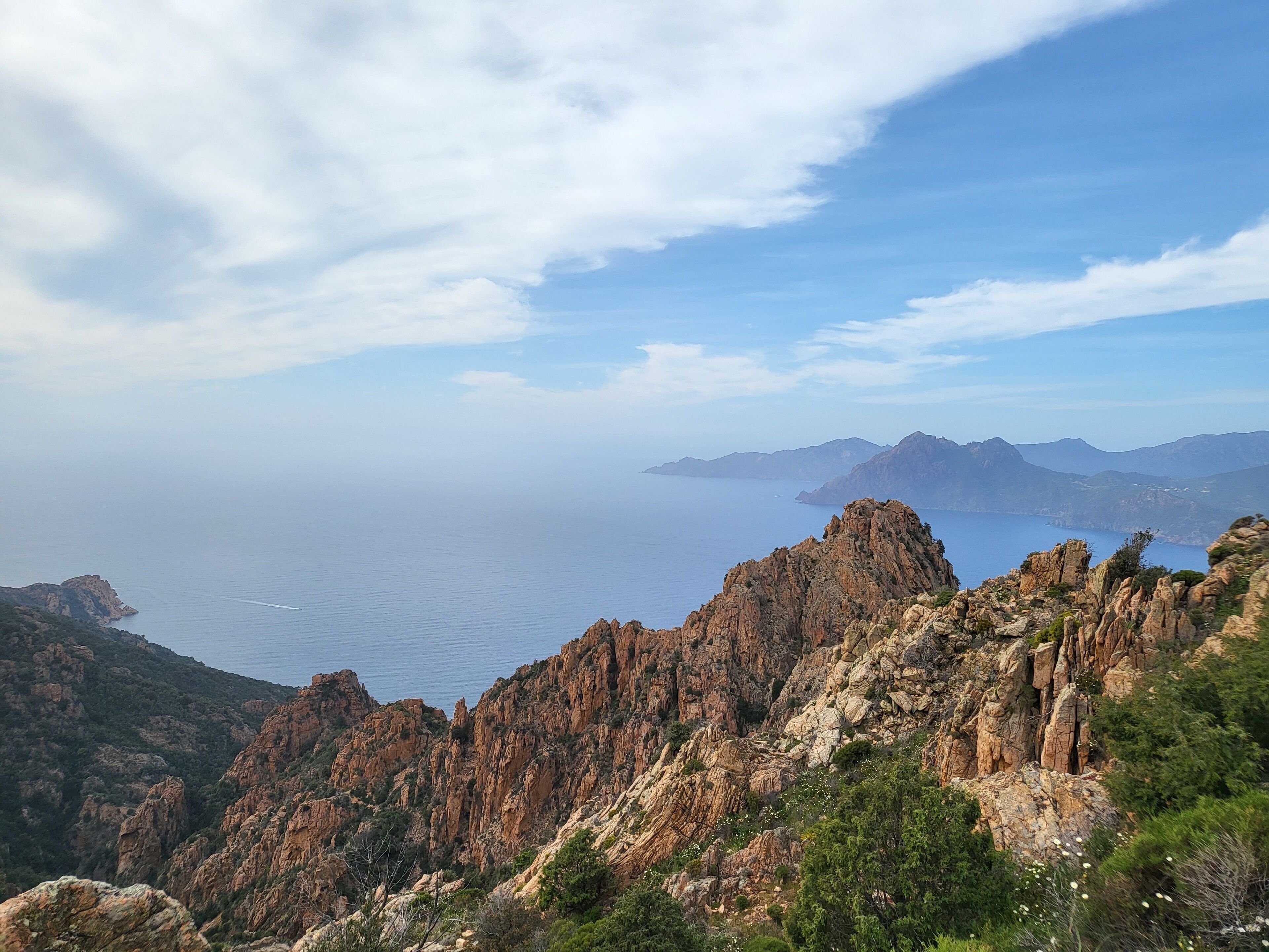 Un paysage montagneux caractérisé par un terrain rocheux et une vue sur la mer.