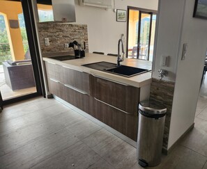Enjoy cooking in this well-equipped kitchen with a central island, induction cooktop, and sink.
