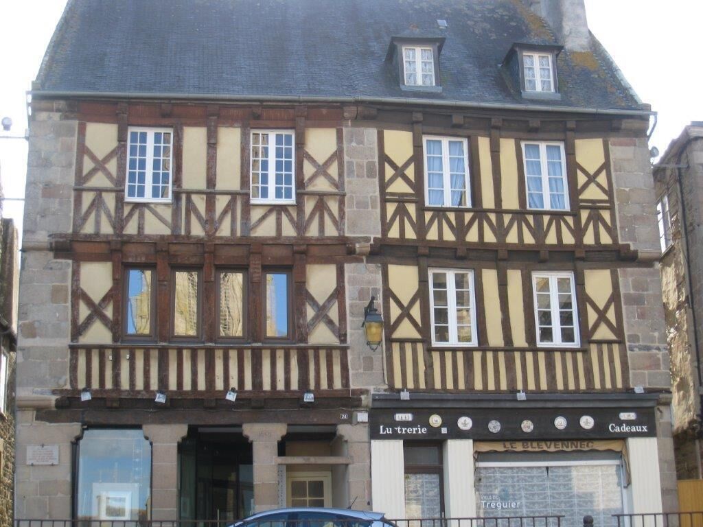 A traditional half-timbered building with a ground floor shop and upper residential units.