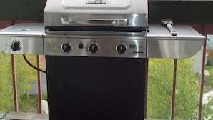A portable grill on a wooden deck with a view of a forested valley. - Affordable Luxury in the Mountains (Dillon)