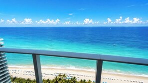 A balcony with a view of a beach and ocean.