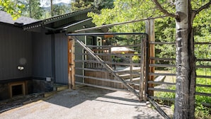 A gated entrance to a building with a stone foundation, a wooden door, and a metal gate.