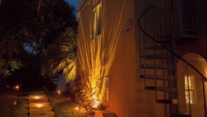Ein Gebäude mit Treppe und Weg, beleuchtet durch Laternen im Boden.