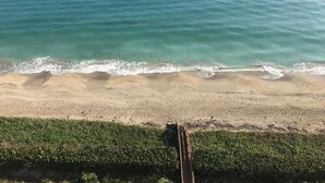 En strand med klart turkis vand og bløde bølger.
