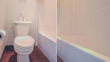 A bathroom with a toilet, a bathtub, and a toilet paper roll.
