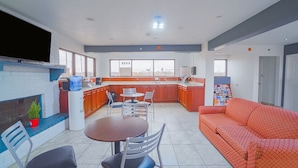 Una cocina moderna con chimenea, comedor con sillas y un sofá.