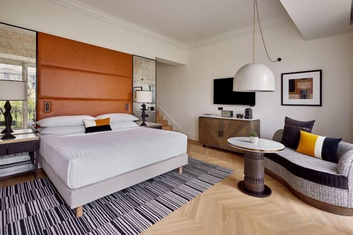 Une chambre d’hôtel moderne équipée d’un grand lit, d’un canapé, d’un bureau et d’une télévision.