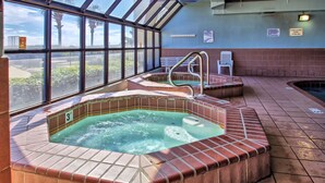 A hot tub area with a glass enclosure, a bench, and a sign indicating a 3 ft depth.
