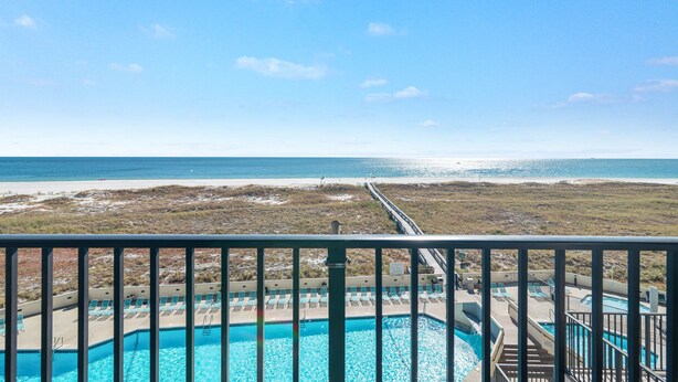 A pool with a view of the beach and ocean.