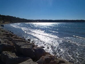 A rocky shoreline with clear blue water and a distant view of a hill. - Large apartment , 1st floor, small garden, beach at 150 m. splendid view (Bandol)