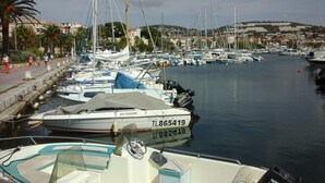 Un puerto deportivo con varias embarcaciones amarradas, incluyendo un lancha rápida con el número TL865419 y un motor fueraborda Yamaha.