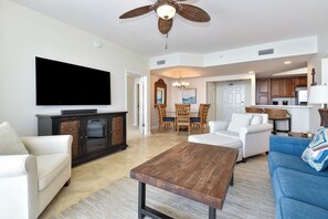 A spacious living room with a flat-screen TV, a wooden coffee table, and a blue sofa. - 2BR 🌊Gulf Front🌊Silver Beach Towers West 1602 (Destin)