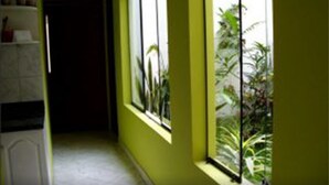 Un couloir avec une fenêtre donnant sur un jardin.
