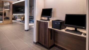 Un área de recepción moderna con un escritorio, computadora y zona de estar.