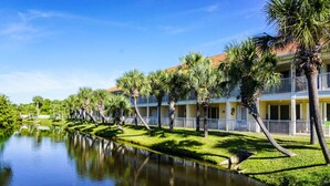 Ein Hotel mit Pool, Palmen und blauem Himmel.