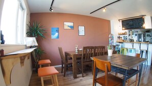 Een gezellig eetgedeelte met houten meubels, een krijtbordmenu en een bar op de achtergrond.