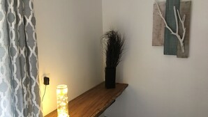 A wooden bench with a wall-mounted light fixture and a vase of branches. - El pasito is the place where you feel good at once (POTRERO)