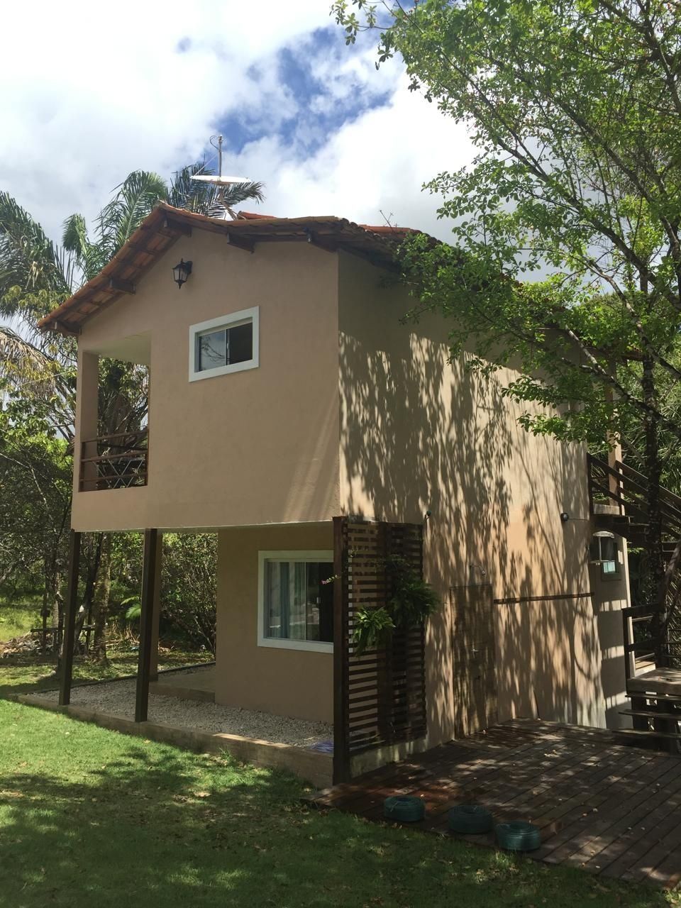 A two-story building with a flat roof, a balcony, and a small window.
