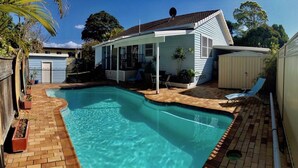 A swimming pool with a sun deck, a covered patio, and a small shed. - ***Coastal Luxury*** Winter special 10% discount*** (Iluka)
