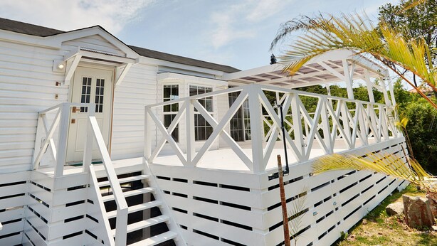 A white wooden house with a porch and a small door. - cottage NORTH OKINAWA (Nakijin)