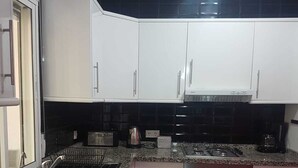 A modern kitchen with white cabinets, a granite countertop, a stainless steel sink, and a built-in oven. - Torrox campo, country house peaceful location, 10 mins drive from Torrox town (Torrox)