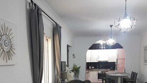 A modern living room with a sofa, armchairs, and a dining table. There is a kitchen in the background with cabinets and a refrigerator. - Torrox campo, country house peaceful location, 10 mins drive from Torrox town (Torrox)