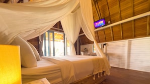 A room with a bed under a canopy, wooden walls, a TV on the wall, and a window with curtains. - Sunset Hill Penida Resort (Penida Island)