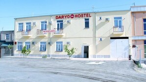 A two-story building with a sign reading "DARIO HOSTEL" and a smaller sign below it.