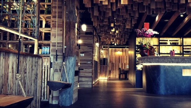 Un interior de madera con una recepción, una balanza y una escalera.