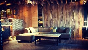Una sala acogedora con un sofá seccional, una mesita de centro y paredes de madera.