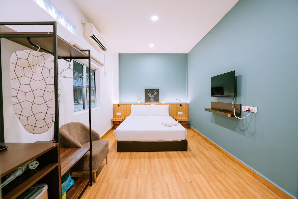 A modern bedroom with a bed, bedside tables, a TV, and a wardrobe.