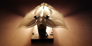Une lampe murale dotée d’un abat-jour transparent aux formes géométriques.
