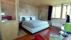 A bedroom with a bed, a nightstand, a desk with a lamp, and a window with curtains. - King Bed - Signature Style (Spring Green)