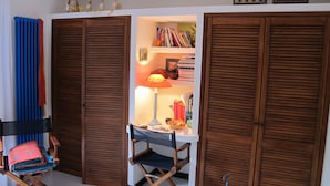 Une pièce comprenant un bureau, une lampe, une chaise et une bibliothèque.
