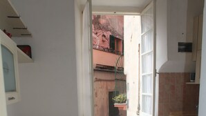 Eine kleine Küche mit Fenster, Tisch und Stuhl.