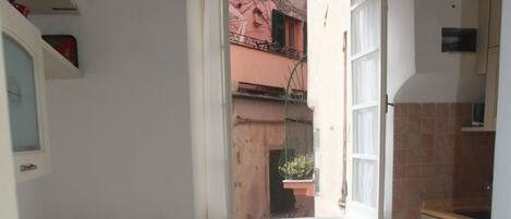 Eine kleine Küche mit Fenster, Tisch und Stuhl.