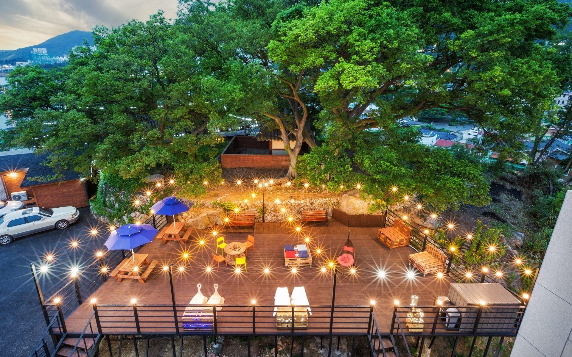 An outdoor seating area with tables, chairs, and string lights.