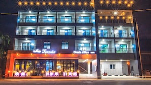 Ein mehrstöckiges Hotel mit Balkonen, einem Restaurant namens „La Terrazza“ und einem Spa-Bereich mit beleuchteten Liegestühlen.