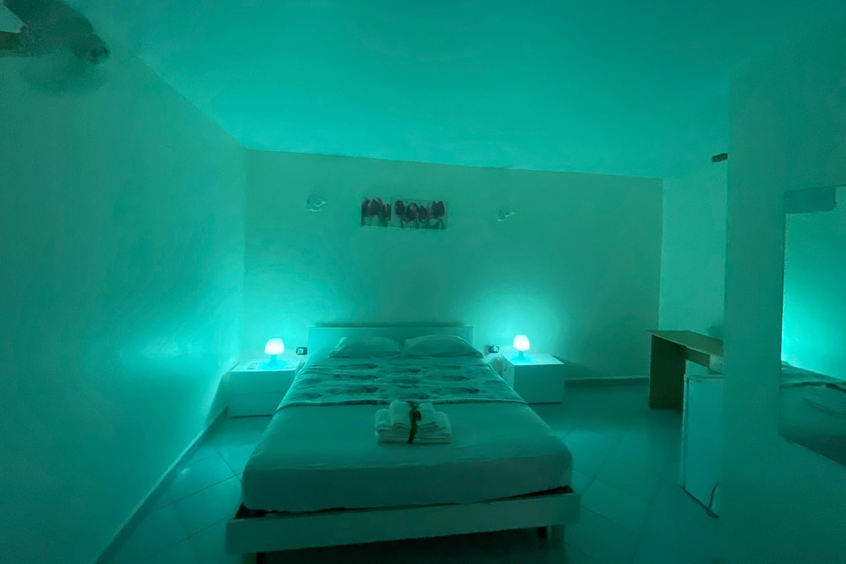 Une chambre comprenant un lit, des tables de chevet et une œuvre d’art accrochée au mur.