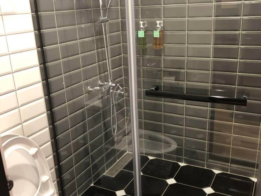 Kylpyhuoneessa on lasiseinällä varustettu suihku, wc ja seinälle asennettu saippua-annostelija.