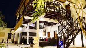 Una casa moderna con escalera, comedor y sala de estar con sofá y mesa.