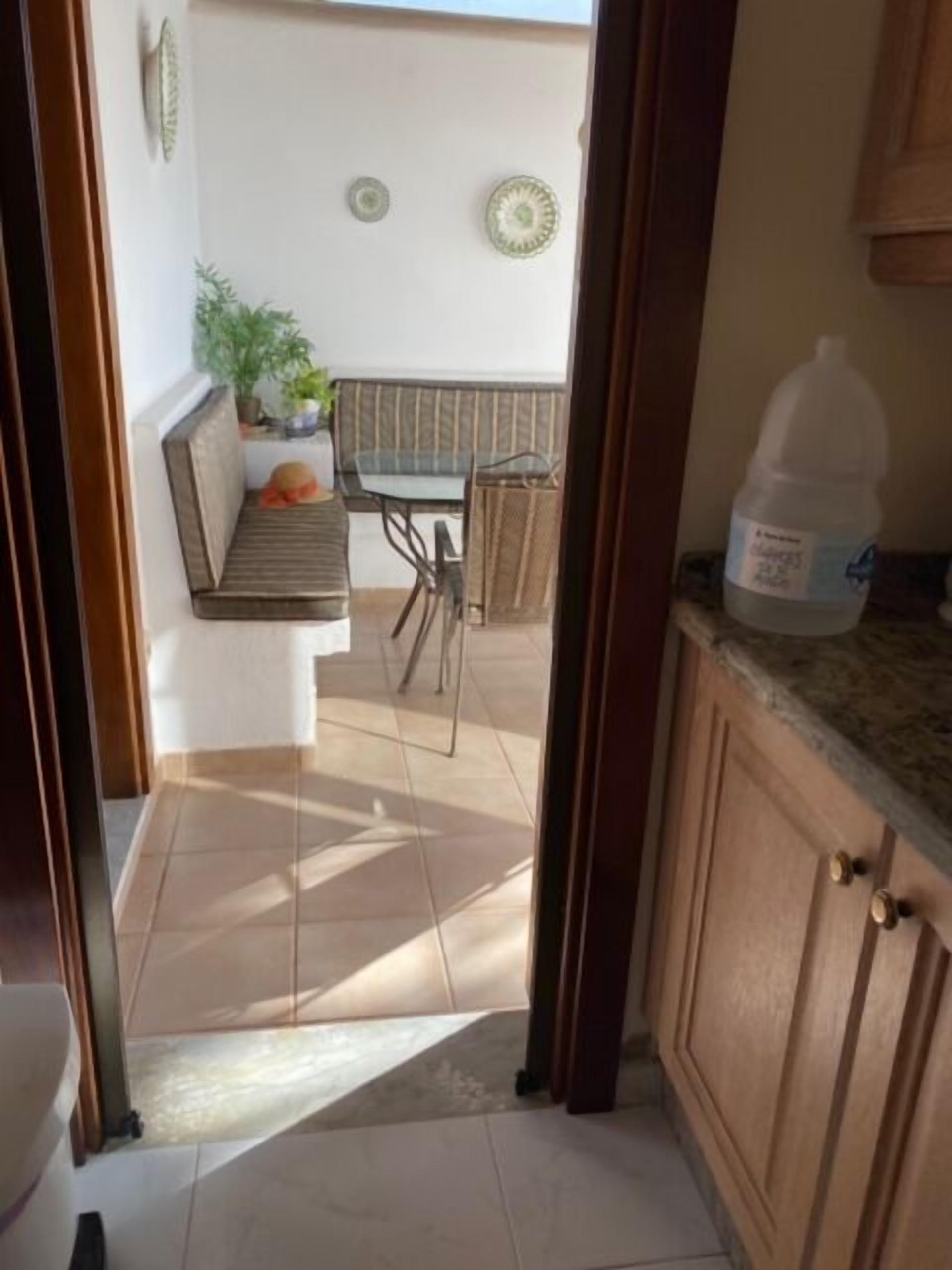 Vista de una cocina con armarios de madera, una encimera y un dispensador de agua grande.