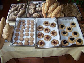 A table with various baked goods including cookies, bread, and pastries. - La Radice (L'Aquila)