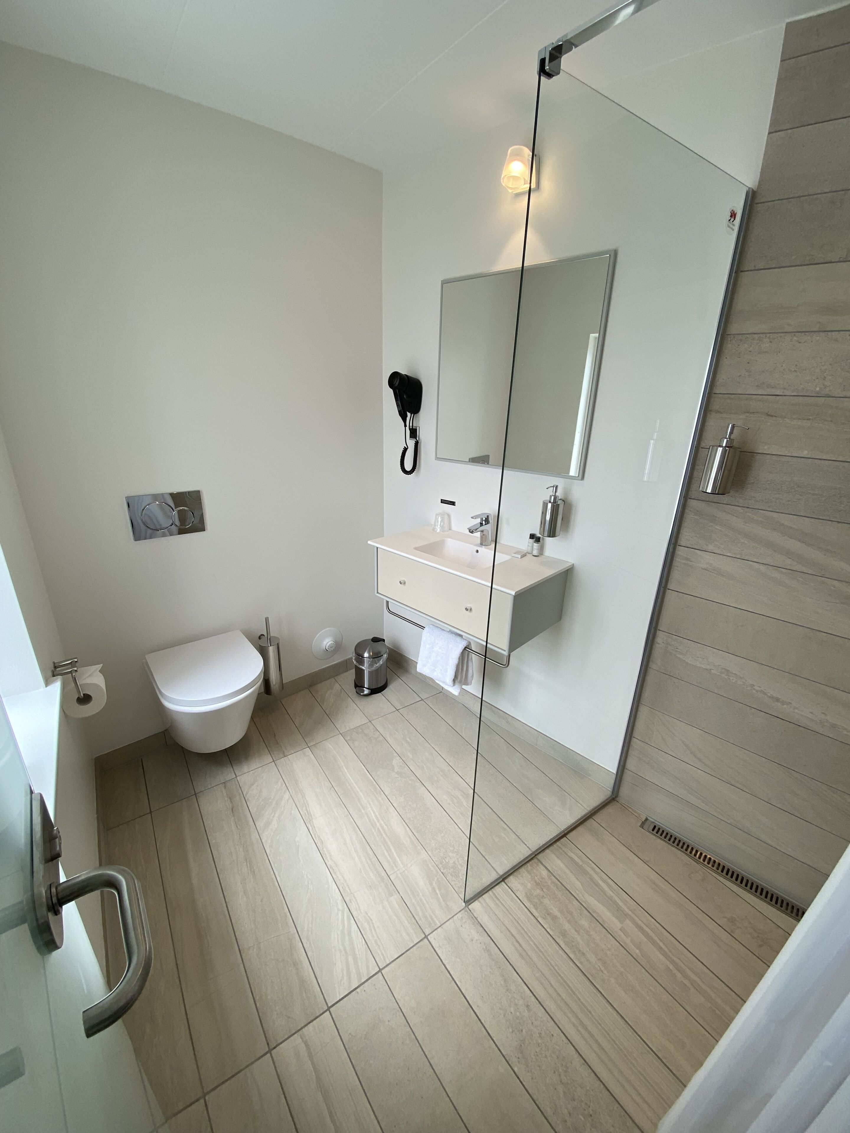 A modern bathroom with a toilet, sink, and shower area.