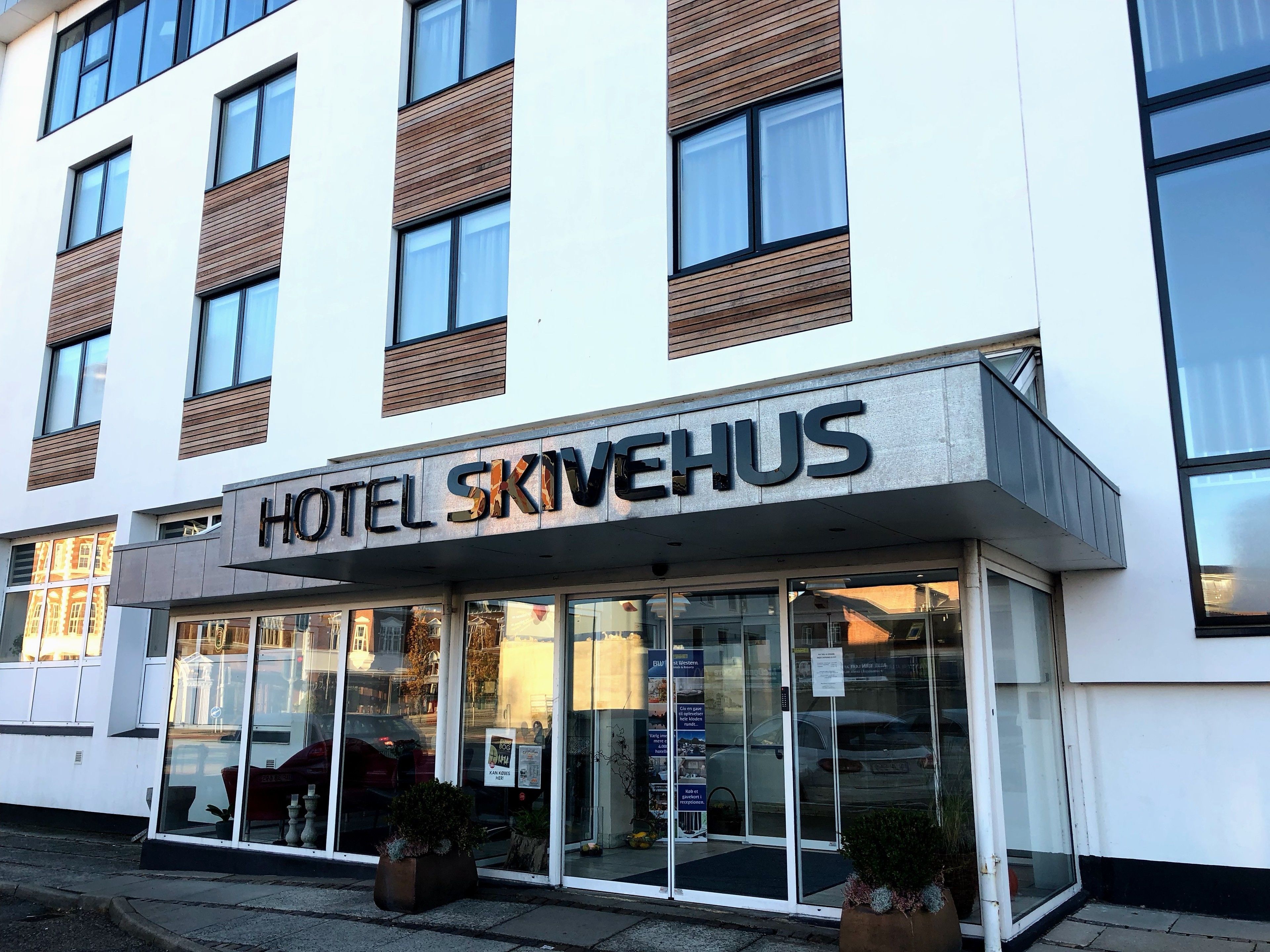 Ein Hotel namens "Hotel Skivehus" mit moderner Fassade, großen Fenstern und einem gut sichtbaren Eingang.
