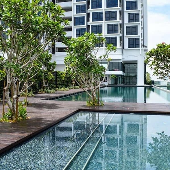 Una piscina al aire libre, camas de piscina gratis, sombrillas