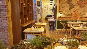 Een restaurant met een bakstenen muur, houten planken en een grote wereldkaart aan de wand.