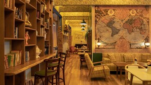 Een knusse bibliotheek met houten boekenplanken, een grote wereldkaart en comfortabele zithoeken.