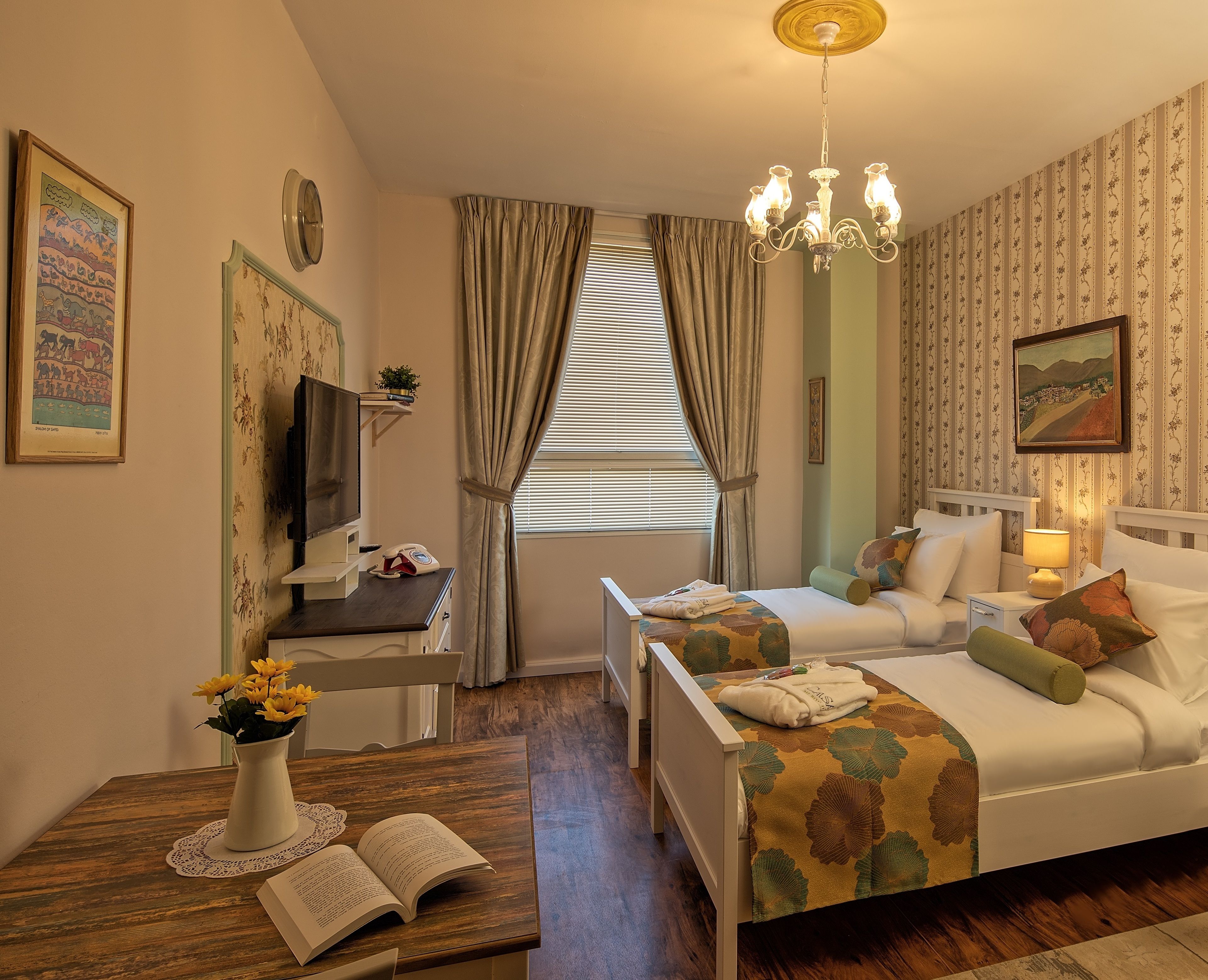 Une chambre d’hôtel confortable, avec un lit, une table de chevet, de la documentation et une fenêtre avec des rideaux.