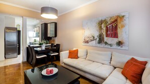Een moderne woonkamer met een bank, salontafel en eethoek.